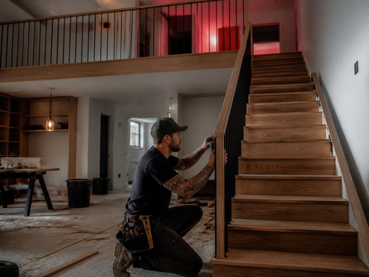 Profissional instalando corrimão e marcenaria em reforma residencial